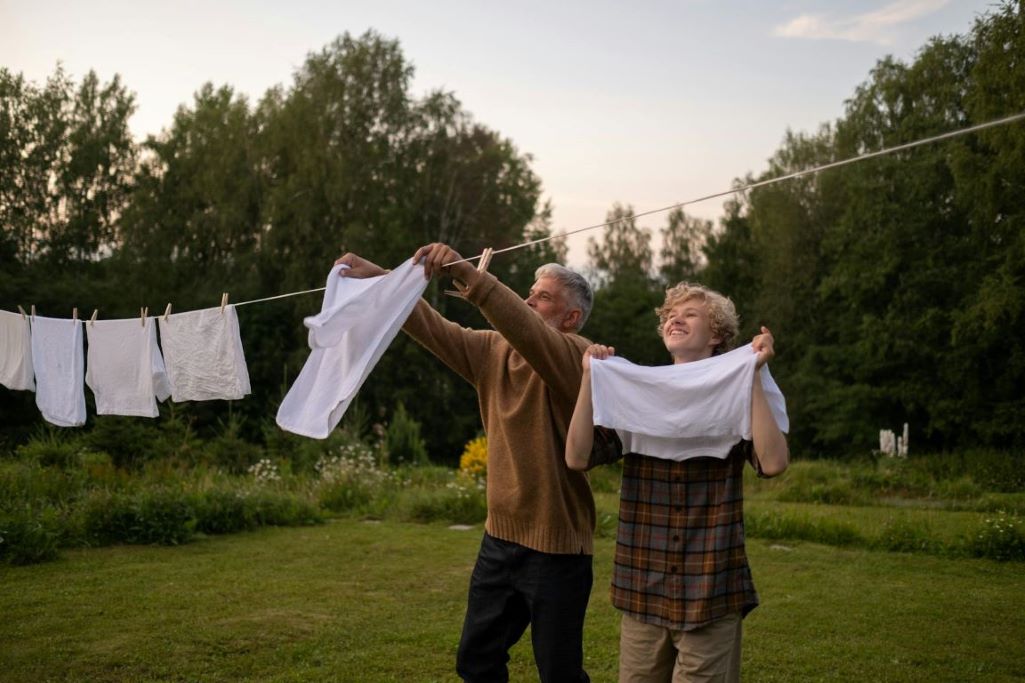 Man and Teenage Boy Hanging Laundry Outside 1