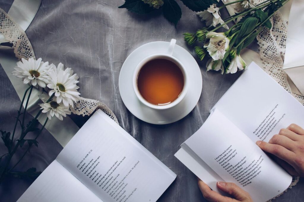 Someone reading a book with a cup of tea in front.